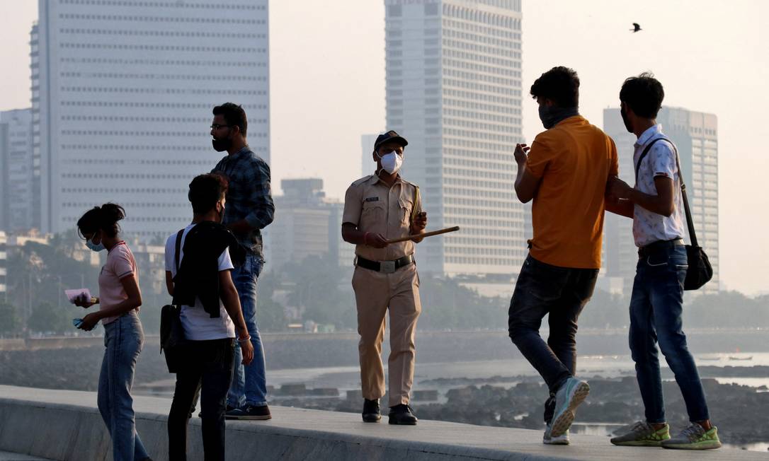 A police officer urges people to leave the marine unit during restrictions to limit public meetings amid the spread of coronavirus in Mumbai. Photo: Naharika Kulkarni/Reuters