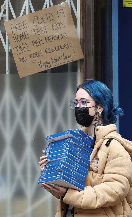 A woman leaves a local government building after collecting free self-test kits for the virus amid the outbreak in London. Photo: Henry Nichols/Reuters