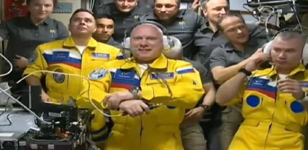 Russian cosmonauts arrive at the station dressed in Ukrainian colors