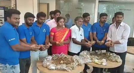 Vetrivel (first from right), family members and dealer employees display coins